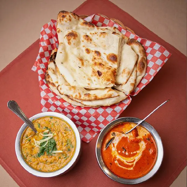 Fresh naan served with two Indian curries