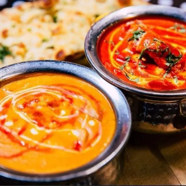 Two colourful Indian curries served with naan